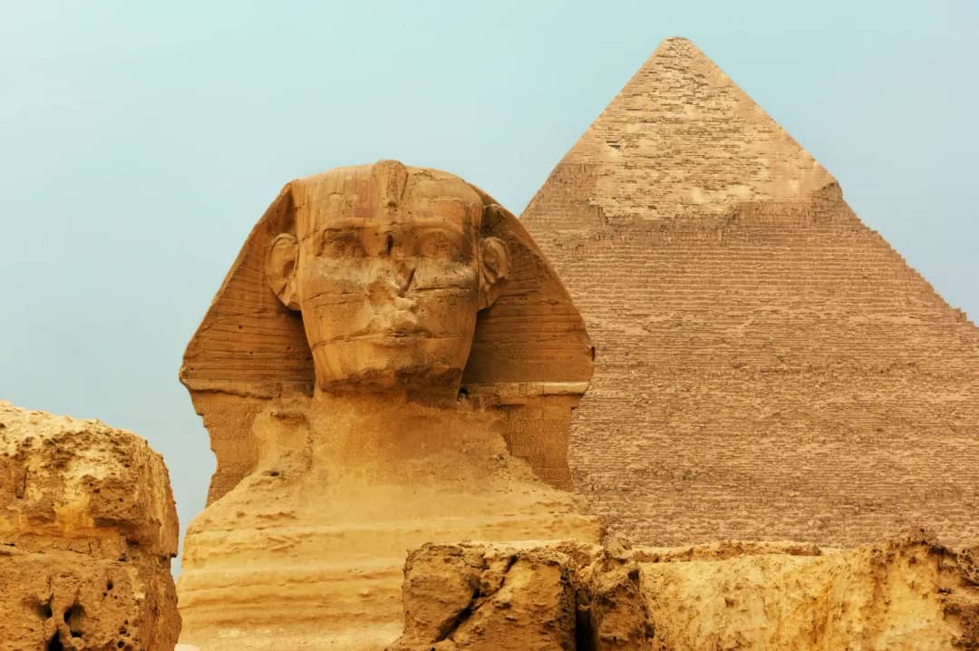 The head of the Great Sphinx of Giza in front of the Pyramid of Khafre, whose upper section keeps its casing stones