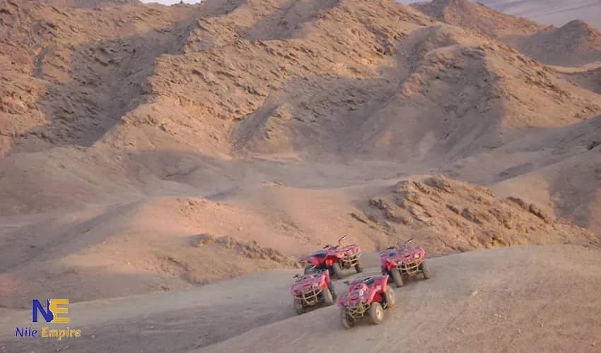 Four red quad bikes among rocky desert hills near Hurghada